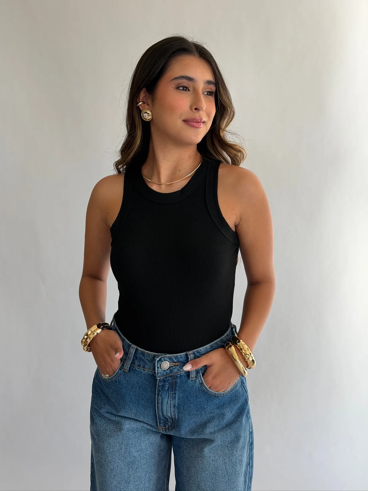 Modelo com regata preta canelada de gola nadador e calça jeans wide leg da Mapa Store